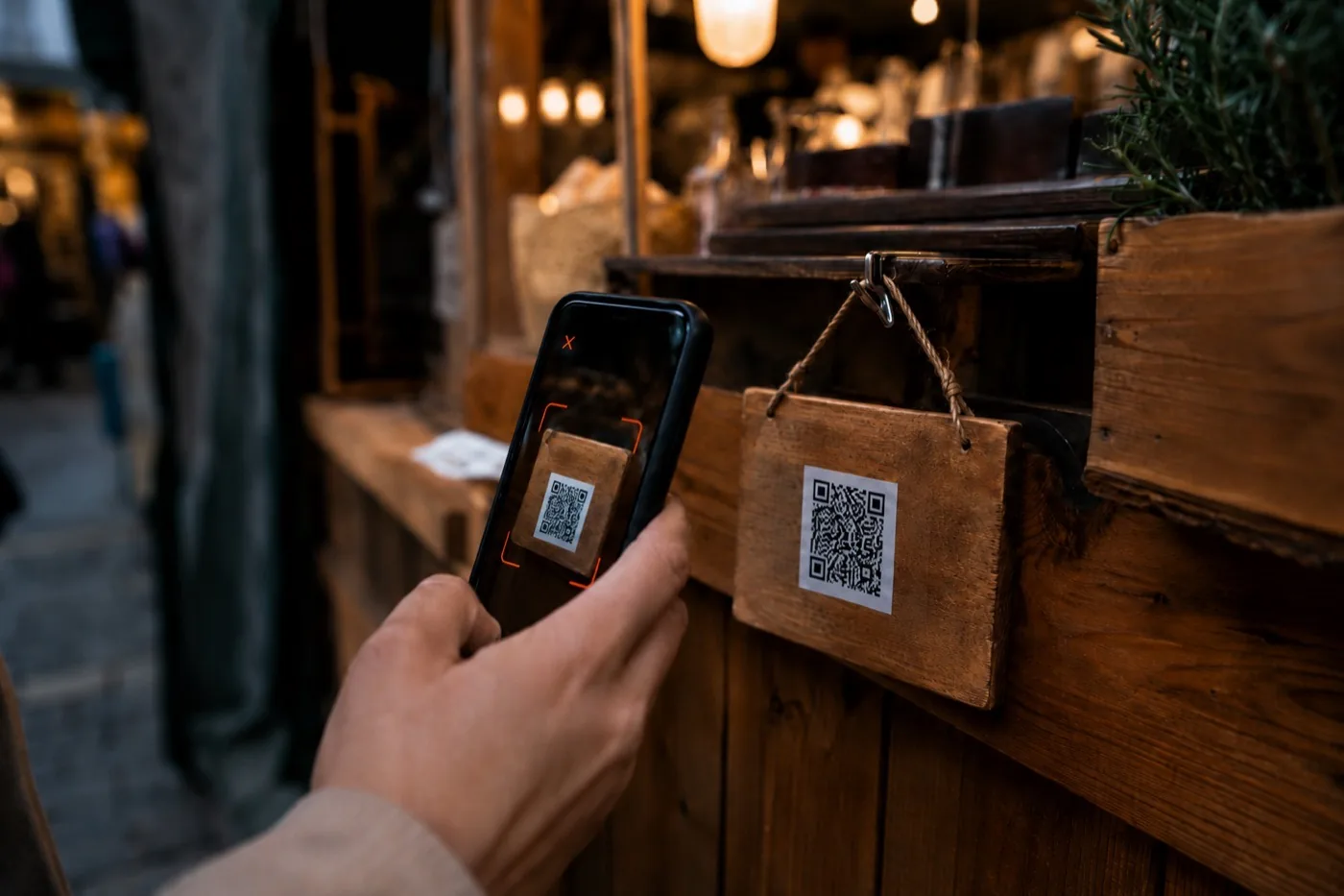 Medewerker scant met de DROP-app de QR-code op het scherm van de verkoopmedewerker aan een marktkraam